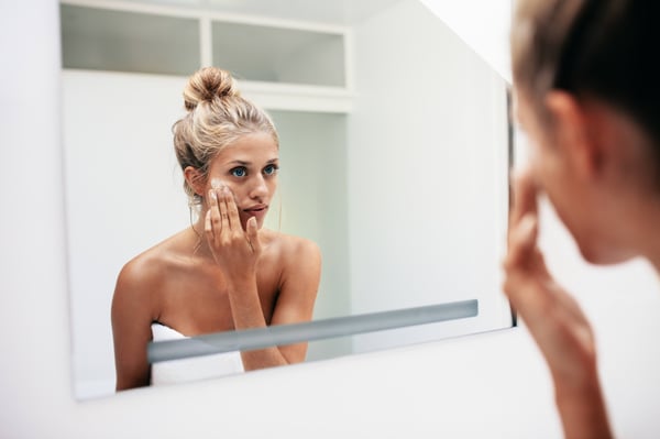 Woman applying skincare product 